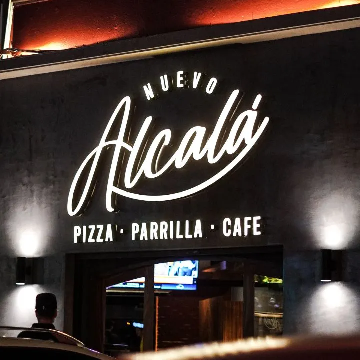 Fachada exterior del bar y pizzería Nuevo Alcalá con su característico letrero iluminado